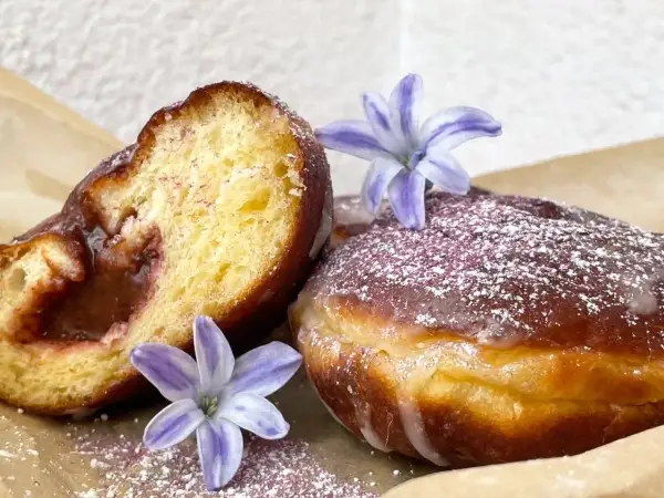 Pyszne paczki z dżemem, posypane cukrem pudrem i ozdobione kwiatami. Idealne na tłusty czwartek, zgodnie z najlepszym paczki przepisem.